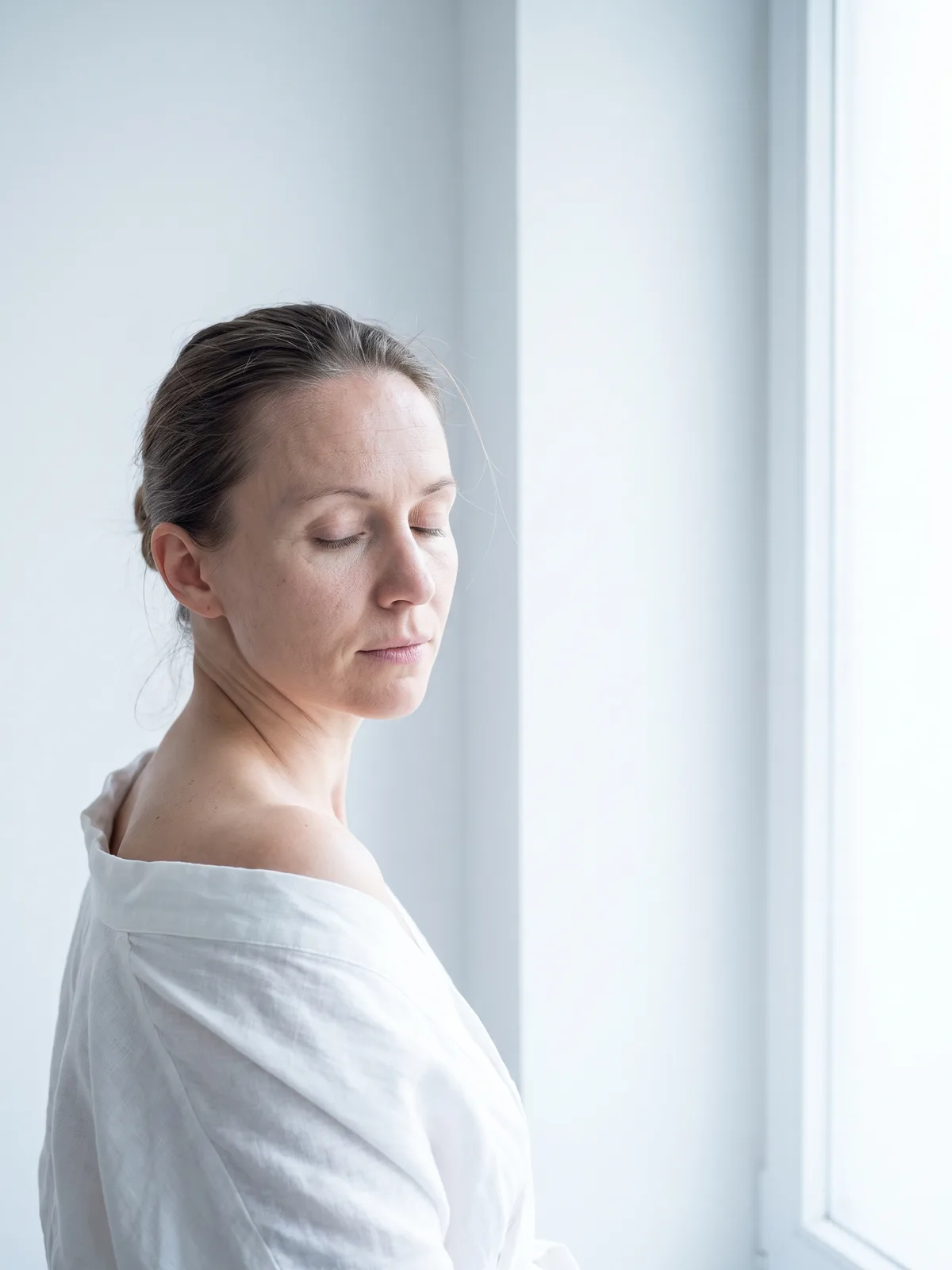 A woman in profile beside a window, in daylight