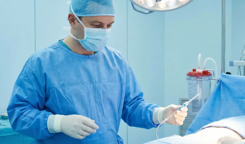 chirurg liposucție în sala de operații cu canulă