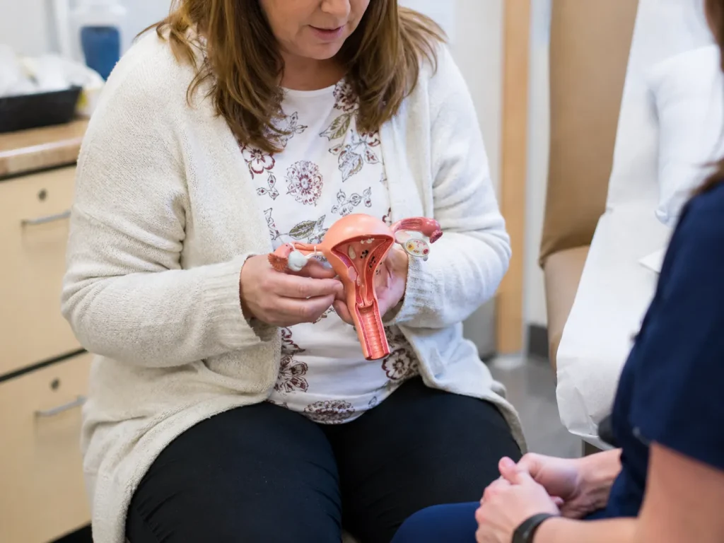 hysterectomy patient holding pelvic anatomy model
